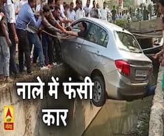 बैक करने के दौरान नाले में फंसी कार। ABP Ganga