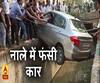 बैक करने के दौरान नाले में फंसी कार। ABP Ganga