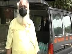 Delhi: Priest Ganganath distributes free water bottles to corona warriors