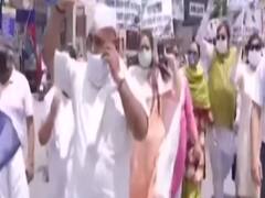 Congress workers pull car with a rope to stage protest against fuel price hike