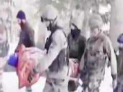 J&K: Indian forces escort woman & her newborn baby amid heavy snowfall in Kupwara