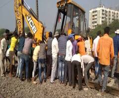 JCB stuck on Railway track | कल्याण-ठाकुर्ली दरम्यान सफाईवेळी जेसीबी रुळावर अडकल्याने वाहतूक ठप्प